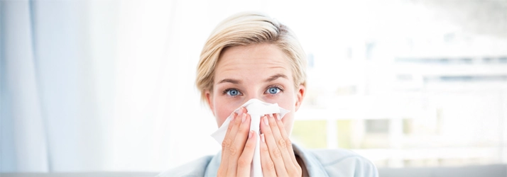 A woman blowing her nose.