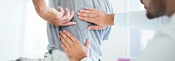 A person pointing to their middle back.