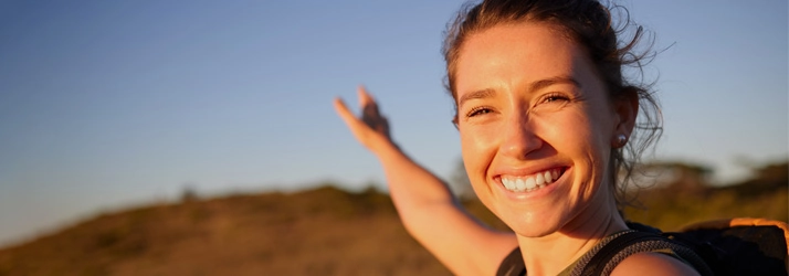 A happy woman smiling outdoors.