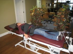 A patient lying on a spinal decompression table.